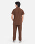A man viewed from the back wearing a matching brown short-sleeve shirt and trousers set, standing against a plain light gray studio background.